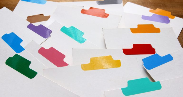 Index Cards with Colour Labels on Wooden Background